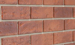 Brick-rustic-red - All Seasons Steel Buildings Close-up of a red brick wall with light gray mortar.