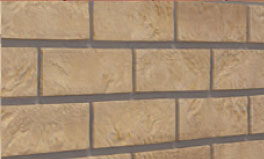 Brick-sand - All Seasons Steel Buildings Close-up of a beige brick wall with dark gray mortar lines.