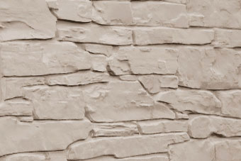 Beige stacked stone wall with irregular rectangular stones and visible mortar lines