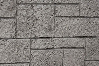 Gray stone wall with rectangular blocks and rough, textured surface.