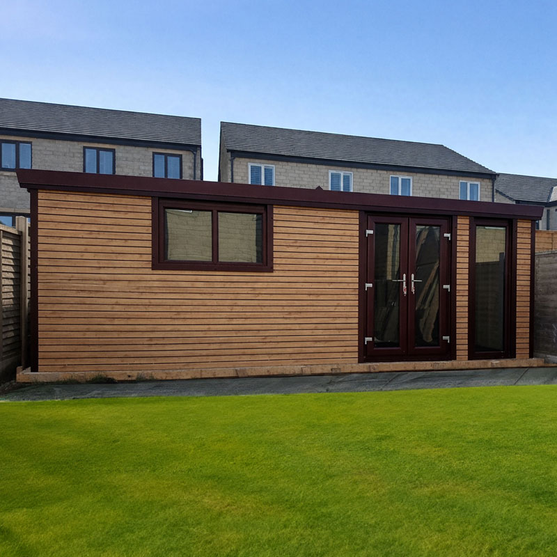 Wooden garden shed with dark burgundy trim, double glass doors, and a side window on a green lawn.